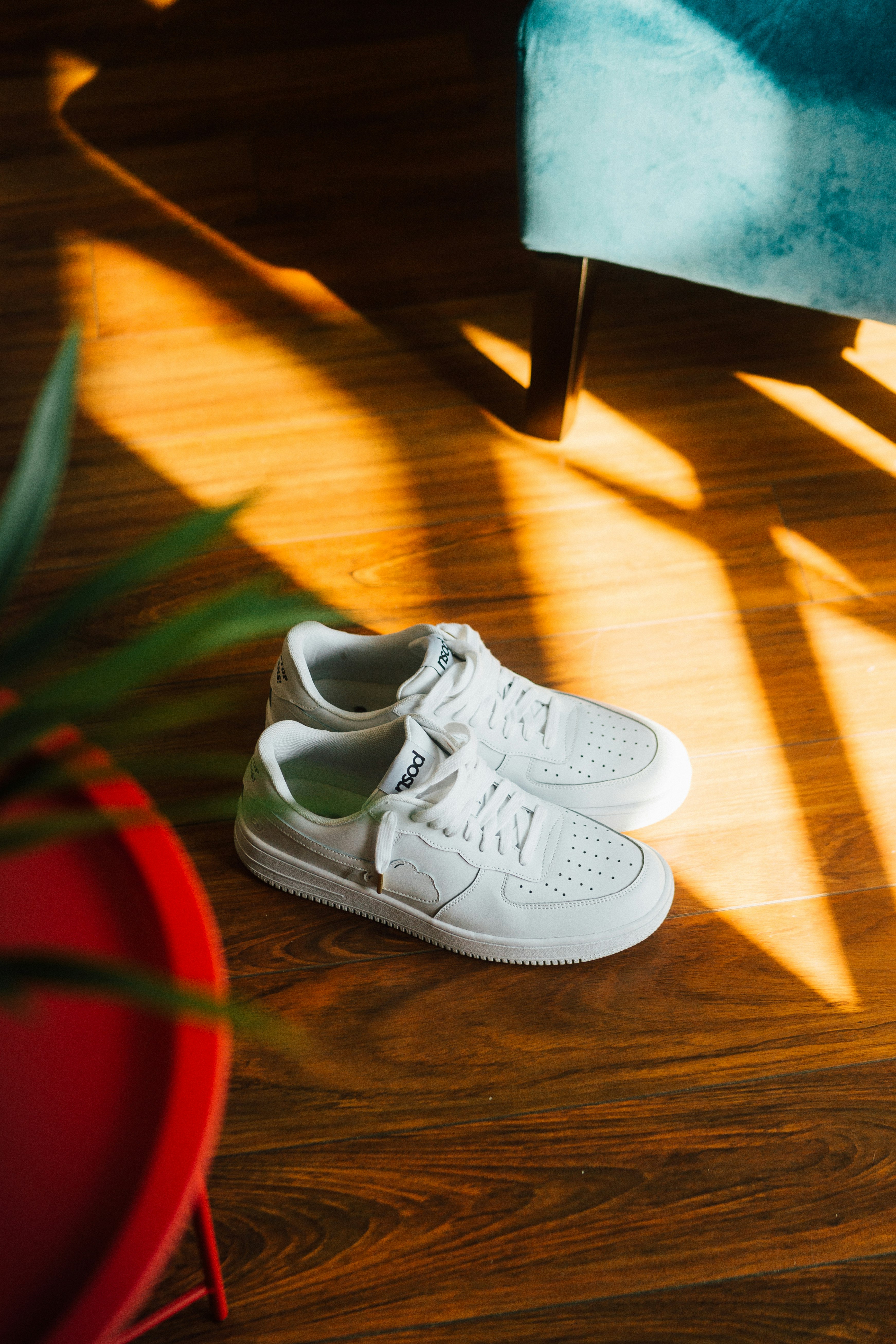 white nike athletic shoes on brown wooden floor